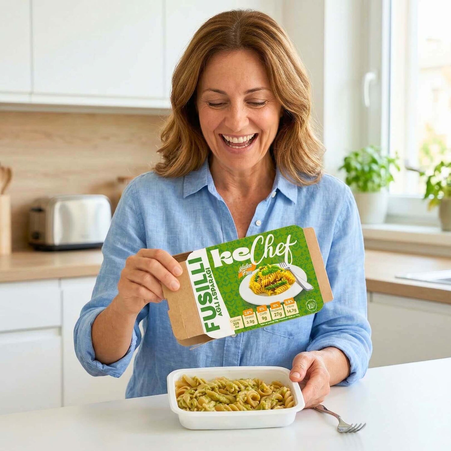 Fusilli keChef agli asparagi Pronti: donna felice apre scatola di pasta fresca con asparagi, ideale per dieta chetogenica.