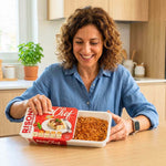 Box X1 settimana piatti pronti: donna felice mentre apre un piatto pronto senza glutine.