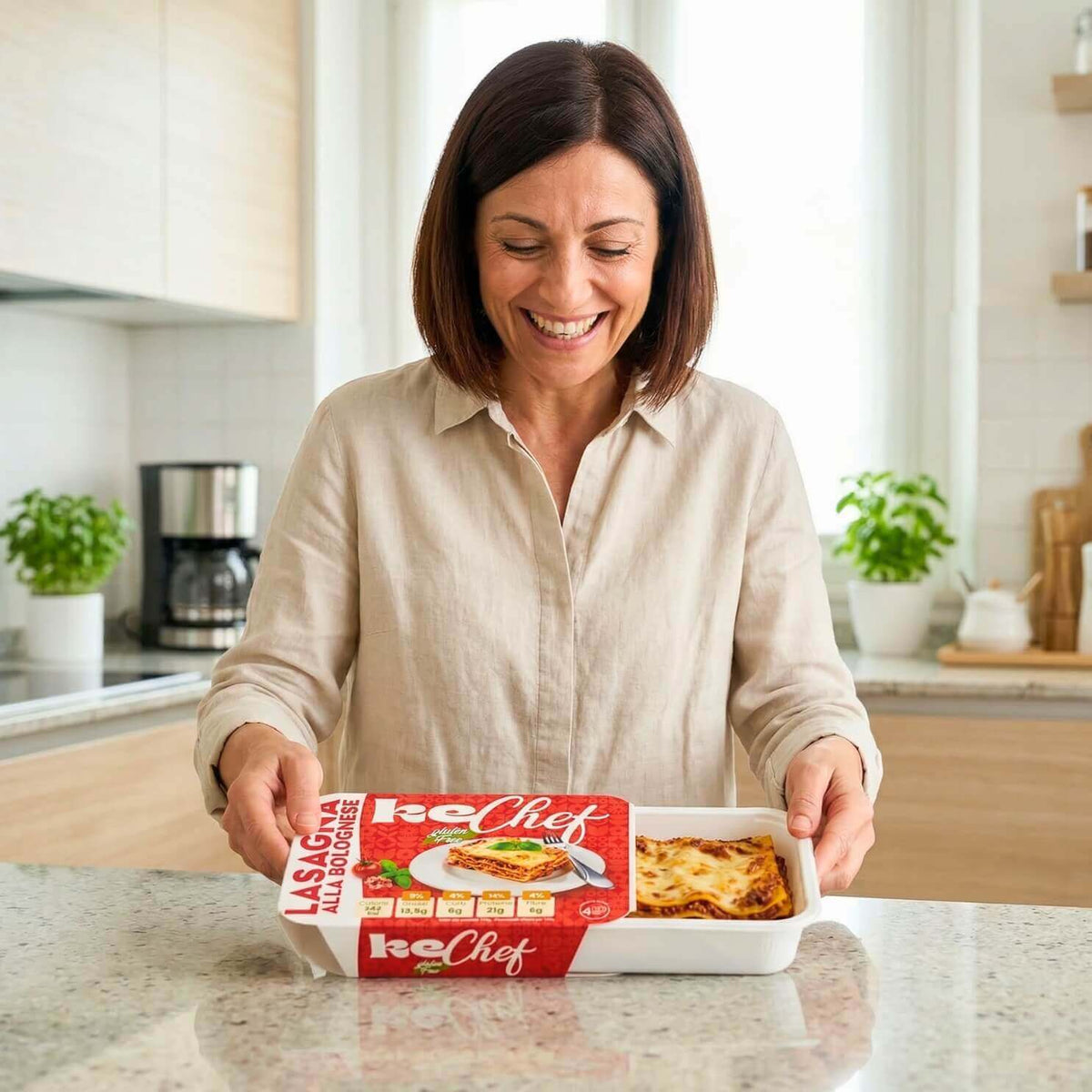 Donna sorridente con la Box G8 Premium Spesa mensile e lasagna pronta da scaldare, ideale per dieta chetogenica.