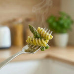 Fusilli keChef agli asparagi Pronti con asparagi verdi su una forchetta, piatto pronto per dieta chetogenica.