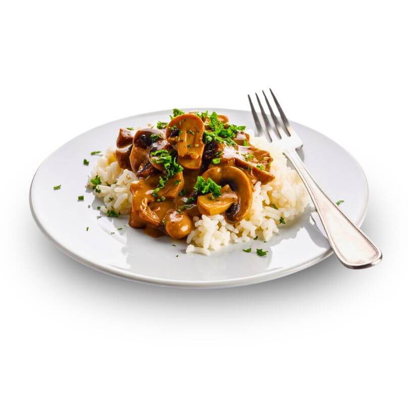 Risoni keto ai funghi serviti su un piatto con riso e guarnizione di prezzemolo freschi.