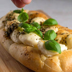 Pinsa proteica con basilico fresco e mozzarella, ideale per dieta chetogenica e alimenti proteici.