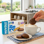 Biscotti proteici Nuvole ricoperti di cioccolato gusto vaniglia accompagnati da una tazza di caffè.