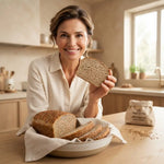 Pane Bauletto Multicereale Keto: donna sorridente con pane su un piatto in cucina, evidenziando alimenti keto.